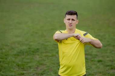 Hakem, hoşnutsuz bir futbol oyuncusu ya da futbolcuya kırmızı kart gösteriyor. Spor anlayışı, kural ihlali, tartışmalı konular, engellerin aşılması