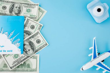 Kamera, pasaport ve uçak açık mavi arka planda. Boşluğu kopyala