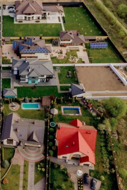 Asfaltlı, yeşil çimenli çimenli, beton zeminli bir evin havadan görünüşü.