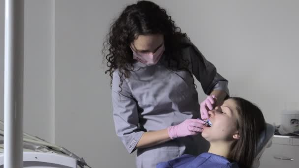 Ortodontista používající zubní otisk na ženských zubech. Zubní špachtle s potiskem pro zubní implantát — Stock video