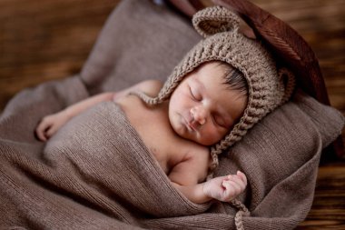 Yeni doğmuş bebek, güzel bebek tahta arka planda kahverengi kürk battaniyesinde yatıyor, 10 günlük kız yatakta uyuyor. Boşluğu kopyala.