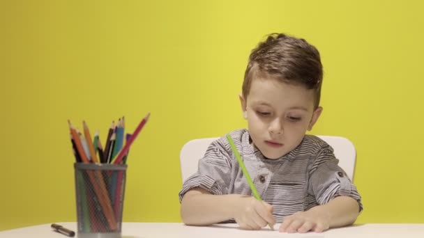 Glimlachend Jongetje Aan Tafel Trekt Met Krijtjes Voor Mama Gele — Stockvideo