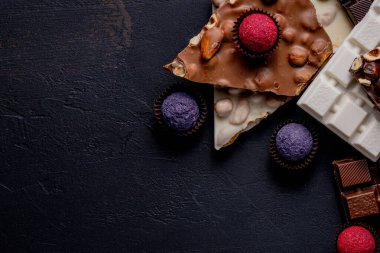 Çikolata arkaplanı. Çikolata. Beyaz, siyah ve sütlü çikolataların karışımı. Çikolatalı Praline tatlılar..