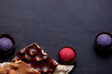 Çikolata, ezilmiş çikolata ve fındık parçaları. Çikolatalı Praline tatlılar. Boşluğu kopyala.