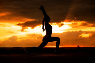 Gün batımı yogası. Gün batımında güzel yoga kızı silueti