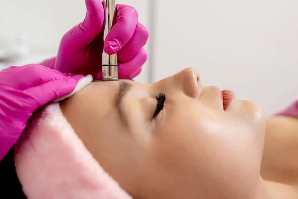 Kosmetolog Wykonuje Zabieg Mikrodermabrazja Skóry Twarzy Pięknej Młodej Kobiety Salonie — Zdjęcie stockowe