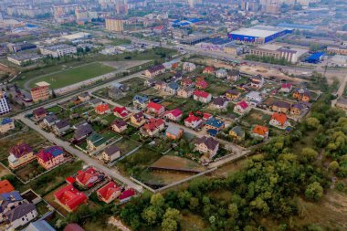 Asfaltlı, yeşil çimenli çimenli, beton zeminli bir evin havadan görünüşü.