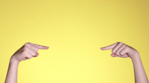 Kadın Elleri Pastel Sarı Arkaplan Üzerinde Telif Boşluğunu Işaret Ediyor — Stok video