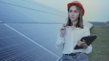 Güneş panellerinin yanında duran genç ve güzel mühendis, Yeşil Enerji Konsepti.