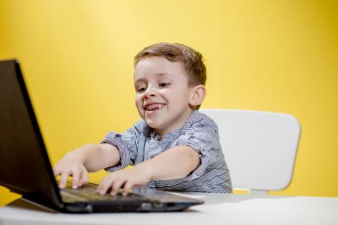 Çocuk blogcu, evde dizüstü bilgisayarla çalışırken kameraya video kaydediyor. Çevrimiçi öğrenme. Çevrimiçi okul