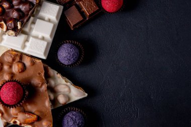 Çikolata, ezilmiş çikolata ve fındık parçaları. Çikolatalı Praline tatlılar. Boşluğu kopyala.