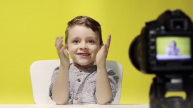 Çocuk blogcu, evde dizüstü bilgisayarla çalışırken kameraya video kaydediyor. Çevrimiçi öğrenme. Çevrimiçi okul