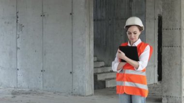 İnşaat alanında çalışan mühendis ya da mimar konsepti. İnşaat alanında tabletli bir kadın. Mimarlık Bürosu