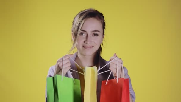 Ung Flicka Tittar Förpackningar Påsar Med Inköp Efter Shopping Pastellgul — Stockvideo