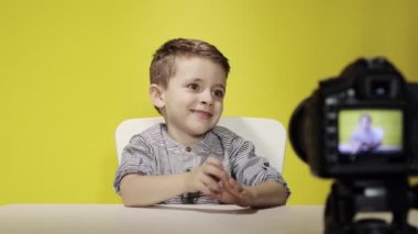 Çocuk blogcu, evde dizüstü bilgisayarla çalışırken kameraya video kaydediyor. Çevrimiçi öğrenme. Çevrimiçi okul.
