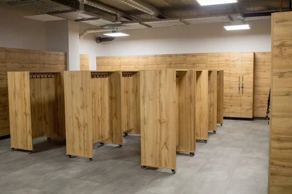 Wooden locker boxes, with metal locks. Classic wood locker room and a bench.