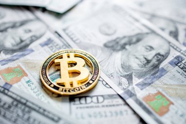 100 dolarlık banknotların üzerinde Bitcoin 'in sembolik sikkeleri. Bitcoin 'i bir dolara değişelim.