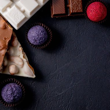 Çikolata arkaplanı. Çikolata. Beyaz, siyah ve sütlü çikolataların karışımı. Çikolatalı Praline tatlılar..