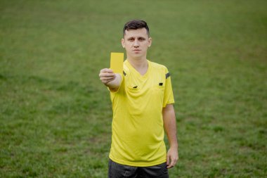 Futbol hakemi, futbol stadyumundaki bir oyuncuya sarı kartı gösterecek..