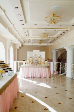 Gelin ve damat için kumaş ve çiçeklerle süslenmiş şölen masası. Taze çiçek kavramı.