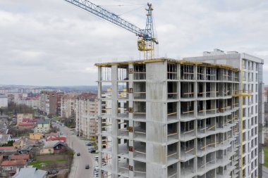 Bir şehirde inşaat halindeki yüksek apartmanın beton çerçevesinin havadan görünüşü