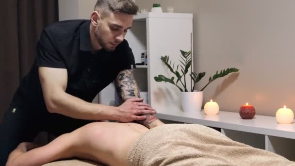 Masseur faisant massage sur le corps de l'homme dans le salon de spa. Concept de traitement beauté. — Video