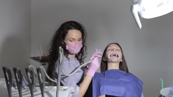 Profesyonel dişçi çürük dişleri muayene eder ve tedavi eder. — Stok video