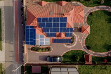 Mavi panelli, yeni, modern bir ev kulübesinin havadan görünüşü. Yenilenebilir ekolojik yeşil enerji üretim kavramı.