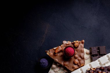 Çikolata, ezilmiş çikolata ve fındık parçaları. Çikolatalı Praline tatlılar. Boşluğu kopyala.