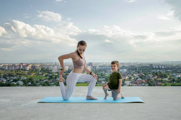 Mãe Filho Fazendo Exercício Varanda Fundo Uma Cidade Durante Nascer — Fotografia de Stock