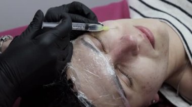 Güzellik salonunda mezoterapi prosedürüyle yüzleş. Güzellik uzmanı kadın derisine enjeksiyon yapar. Mezoterapi, biyo-evitalizasyon. Yakın çekim. Seçici odak