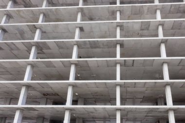 Bir şehirde inşaat halindeki yüksek apartmanın beton çerçevesinin havadan görünüşü