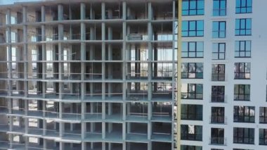 İnşaat halindeki yüksek apartmanın havadan görüntüsü. Yeni apartman cephesinin birçok penceresi yapım aşamasında. Gayrimenkul geliştirme
