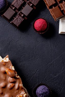 Çikolata arkaplanı. Çikolata. Beyaz, siyah ve sütlü çikolataların karışımı. Çikolatalı Praline tatlılar..