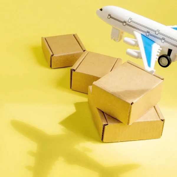 Shadow Airplane and stack of cardboard boxes. concept of air cargo and parcels, airmail. Fast delivery of goods and products. Cargo aircraft. Logistics, connection to hard-to-reach places.