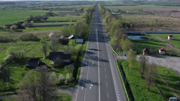 Аерофотозйомка автомобілів, що їздять по порожньому рейді уздовж дерев і полів — стокове відео