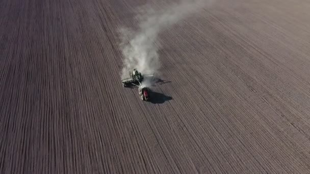 Levegőlátó traktor borona rendszerrel szántó föld művelt mezőgazdasági területen — Stock videók