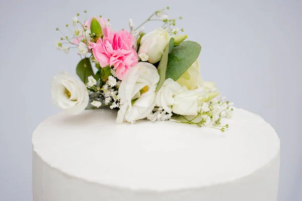 Tiered cake for wedding or birthday. Beautiful white and pink festive cake decorated with flowers