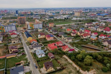 Asfaltlı, yeşil çimenli çimenli, beton zeminli bir evin havadan görünüşü.
