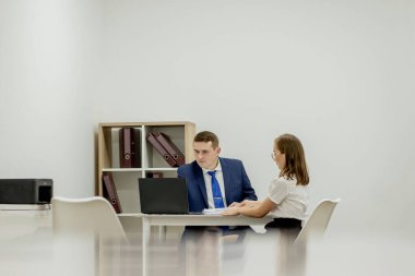 Bir masaüstü bilgisini ofisindeki kağıt belgeyle karşılaştıran iş adamları.