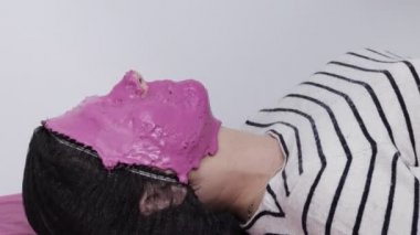 Güzellik Salonunda Kozmetik Maskeli Kapalı Kadın. Pembe Nemlendirici Aljinat Maskeli Genç Kadın. Güzellik Tedavisi.