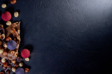 Çikolata, ezilmiş çikolata ve fındık parçaları. Çikolatalı Praline tatlılar. Boşluğu kopyala.