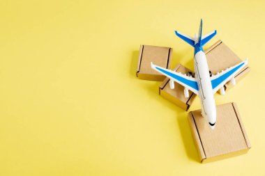 Uçak ve karton kutular. Hava kargo ve paket kavramı, havayolu postası. Mal ve ürünlerin hızlı teslimatı. Kargo uçağı. Lojistik, ulaşılması zor yerlerle bağlantı. Banner, boşluğu kopyala