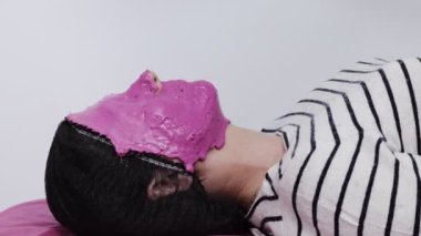 Güzellik Salonunda Kozmetik Maskeli Kapalı Kadın. Pembe Nemlendirici Aljinat Maskeli Genç Kadın. Güzellik Tedavisi.