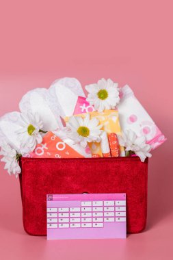 Pamuk tamponlu, hijyenik pedli, beyaz çiçekli adet takvimi. Kadın kritik günler, kadın hijyen koruması