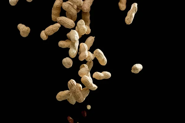 Movimento de congelamento realista de amendoins voadores em fundo preto — Fotografia de Stock