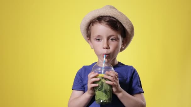 Netter Junge Trinkt Mojito Cocktail Aus Plastikbecher Über Gelbem Studiohintergrund — Stockvideo