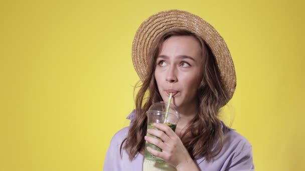 驚くべき女性黄色のスタジオの背景にプラスチックカップからモヒートカクテルを飲む 夏のリフレッシュ 冷たい飲料 — ストック動画