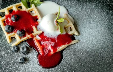 Dondurma, taze yaban mersini ve nane aromalı taze ev yapımı klasik Belçika waffleları. Lezzetli waffle. Kahvaltı konsepti.