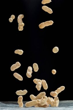 Siyah arka planda uçan fıstıkların gerçekçi dondurucu hareketi.